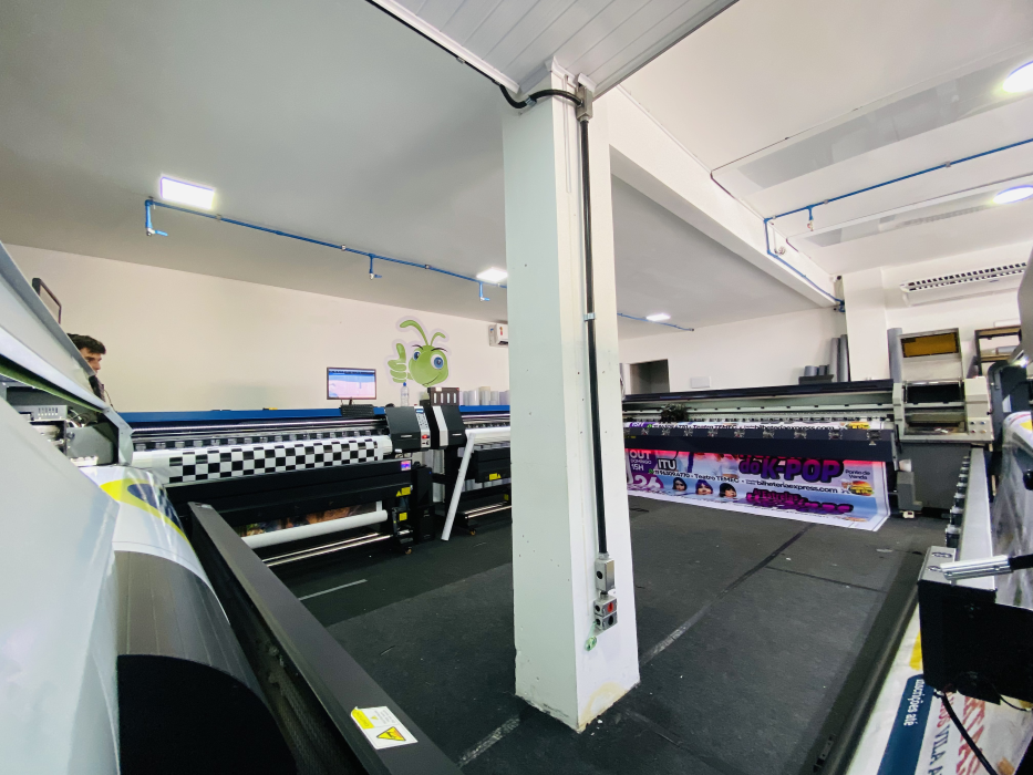 Área de produção da Criarte com equipamentos de impressão em grande formato
