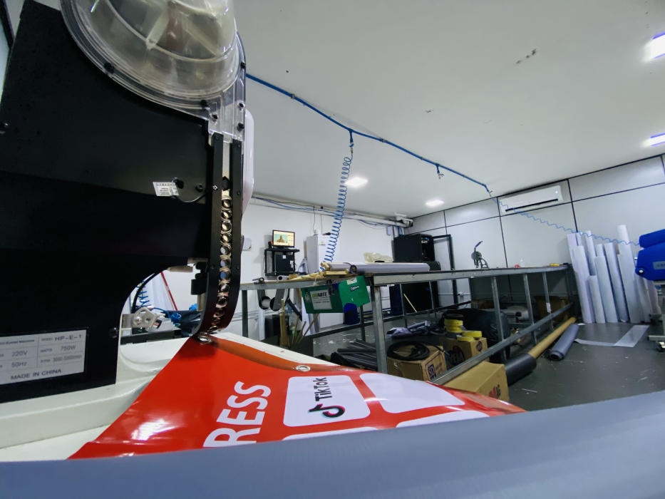 Equipamento de acabamento trabalhando sobre material impresso vermelho