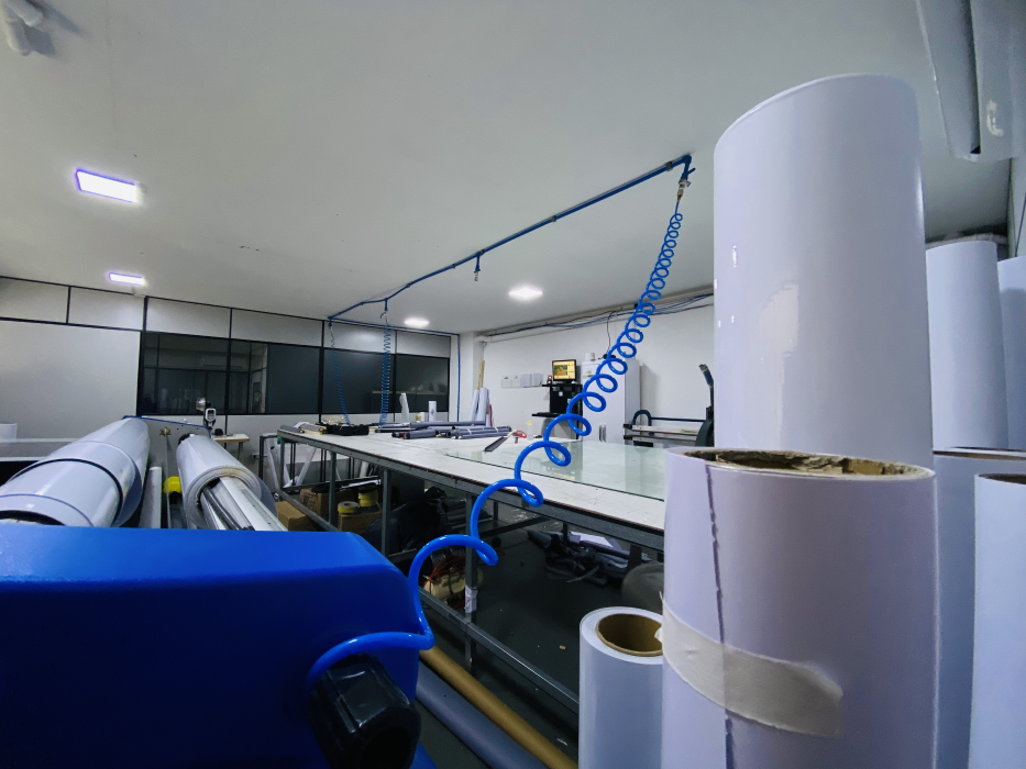 Bancada de produção com rolos de materiais e equipamentos da Criarte