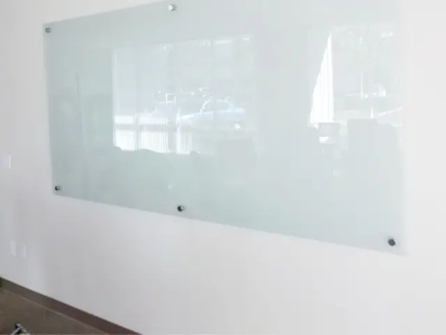 Lousa de vidro sob medida instalada em ambiente comercial ou corporativo.