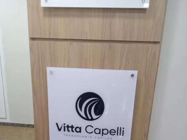 Placa de vidro adesivada instalada em ambiente comercial ou corporativo.
